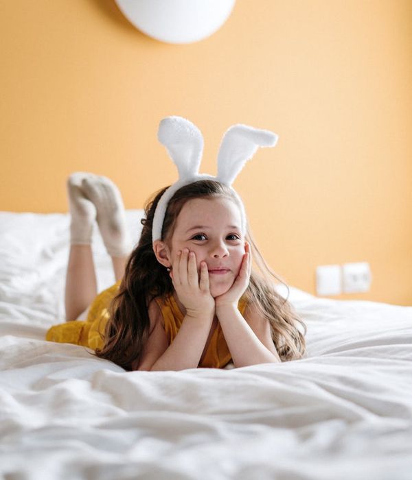 Happy children doing a playful yoga pose in a bright room.